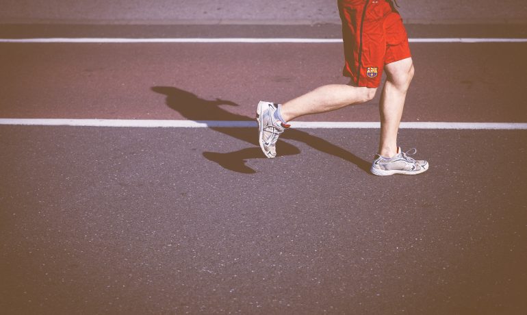 man-running-on-concrete-road-in-sun